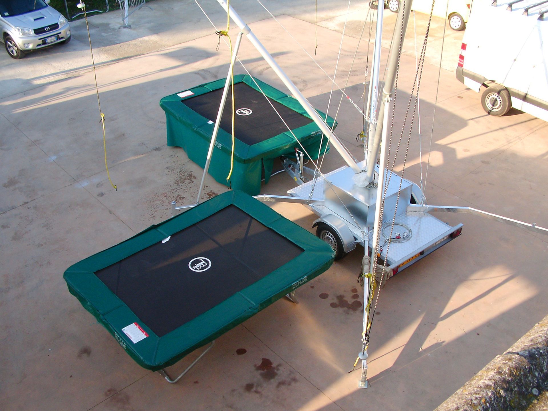 Due trampolini verdi, uno su un rimorchio, con una struttura di supporto bianca.