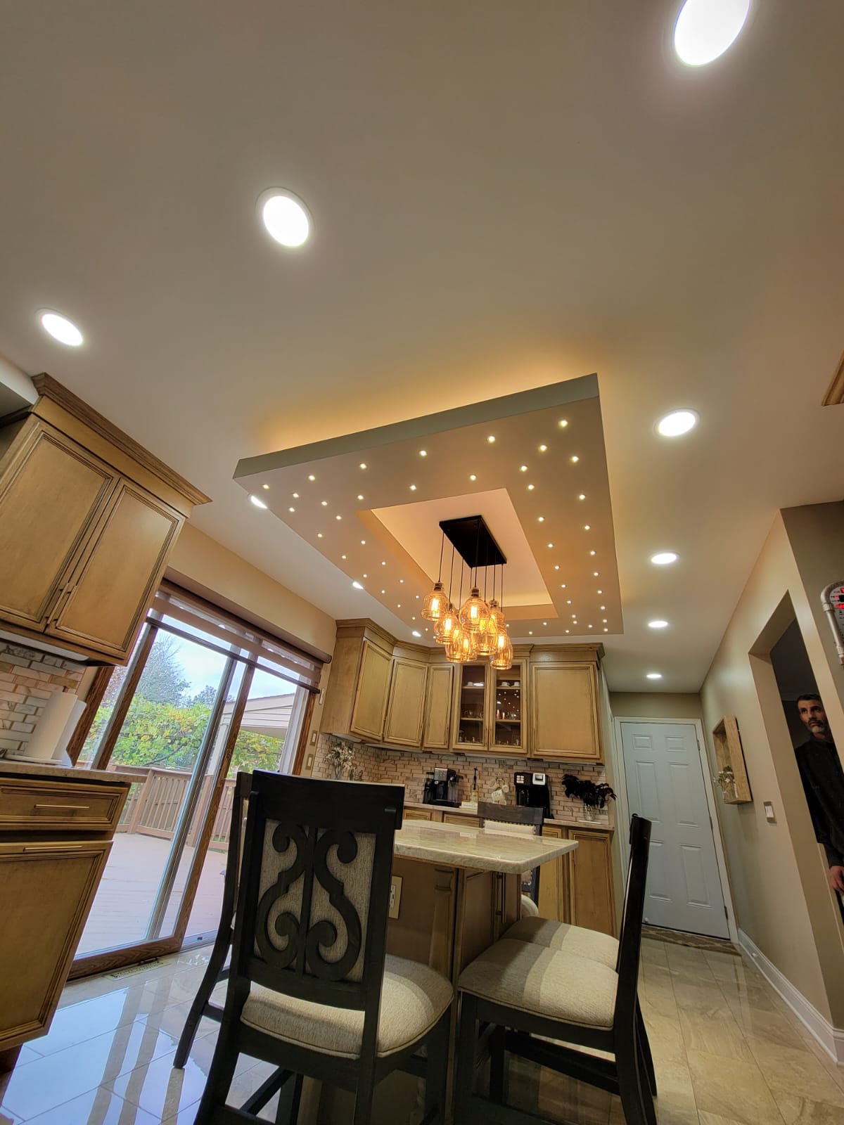 Kitchen with light-colored cabinets, a breakfast bar, and a unique starry-light ceiling fixture.