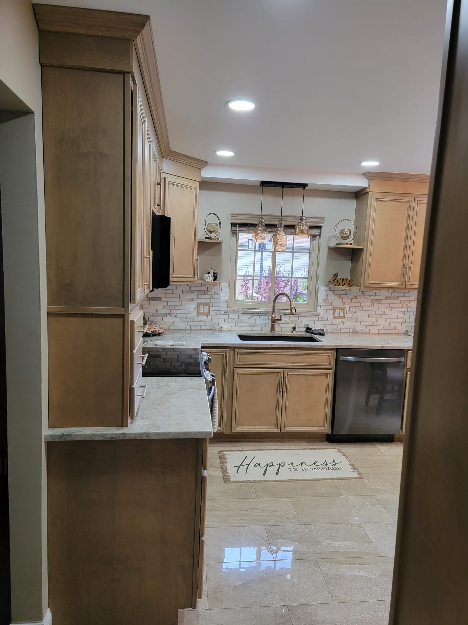 Tan kitchen with cabinets, sink, and a 