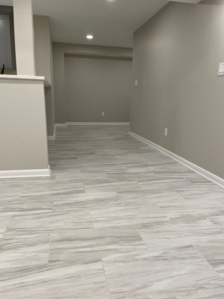 Empty room with light gray-wood-look tiled floor and light gray walls.