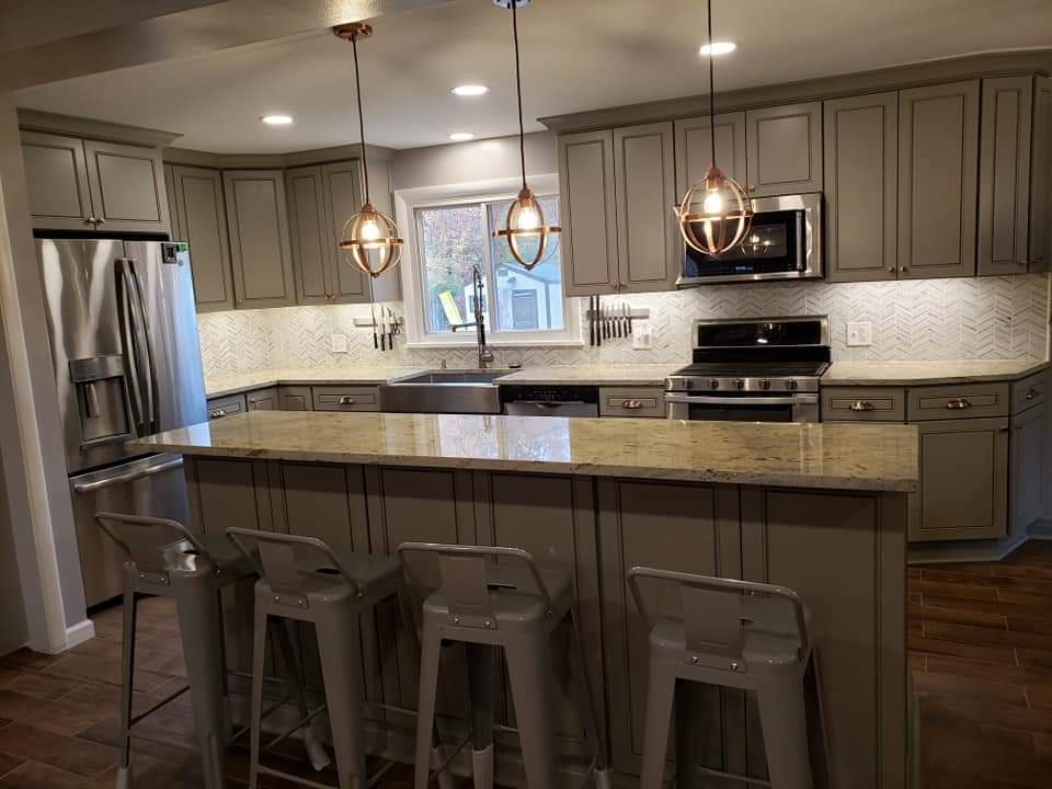 Gray kitchen with granite countertops, stainless steel appliances, and copper pendant lights.