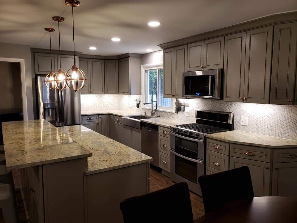 Modern kitchen with gray cabinets, granite countertops, and stainless steel appliances.
