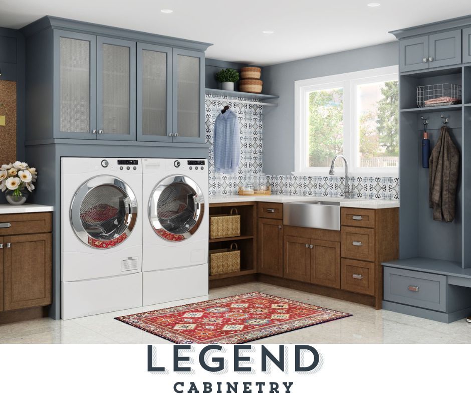 Laundry room with blue and brown cabinetry, white appliances, and a red rug.