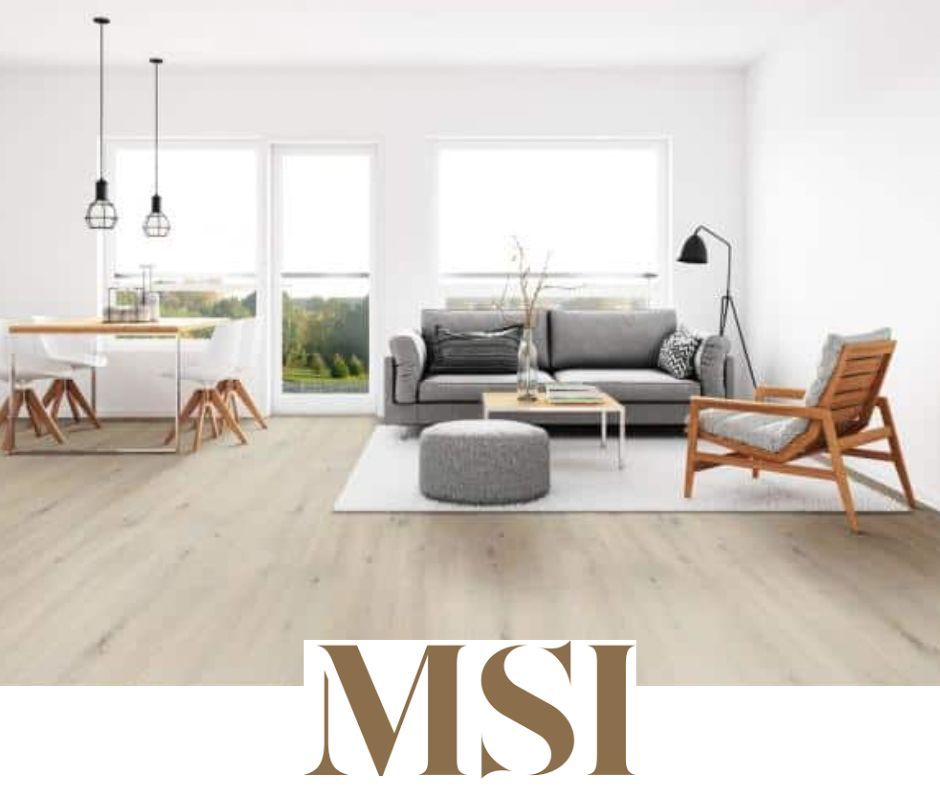 Living room with light wood floors, gray sofa, white walls, and a view through the windows.