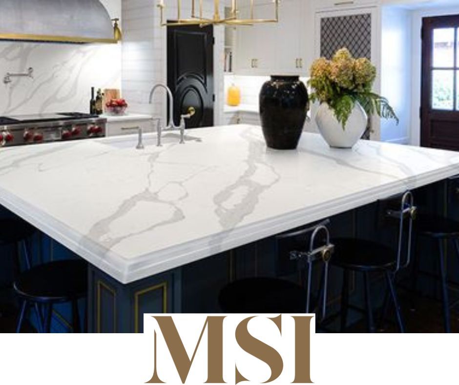 Kitchen island with white marble countertop, dark cabinets, and stools. MSI logo at bottom.