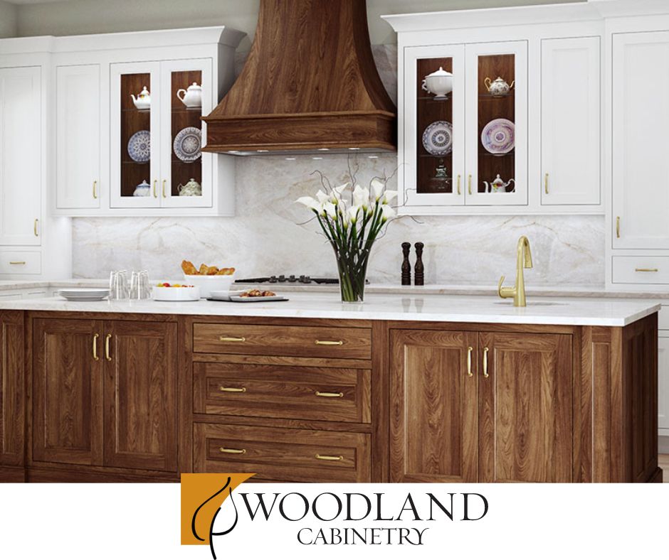 Kitchen with white cabinets, wood island and hood, and marble backsplash.