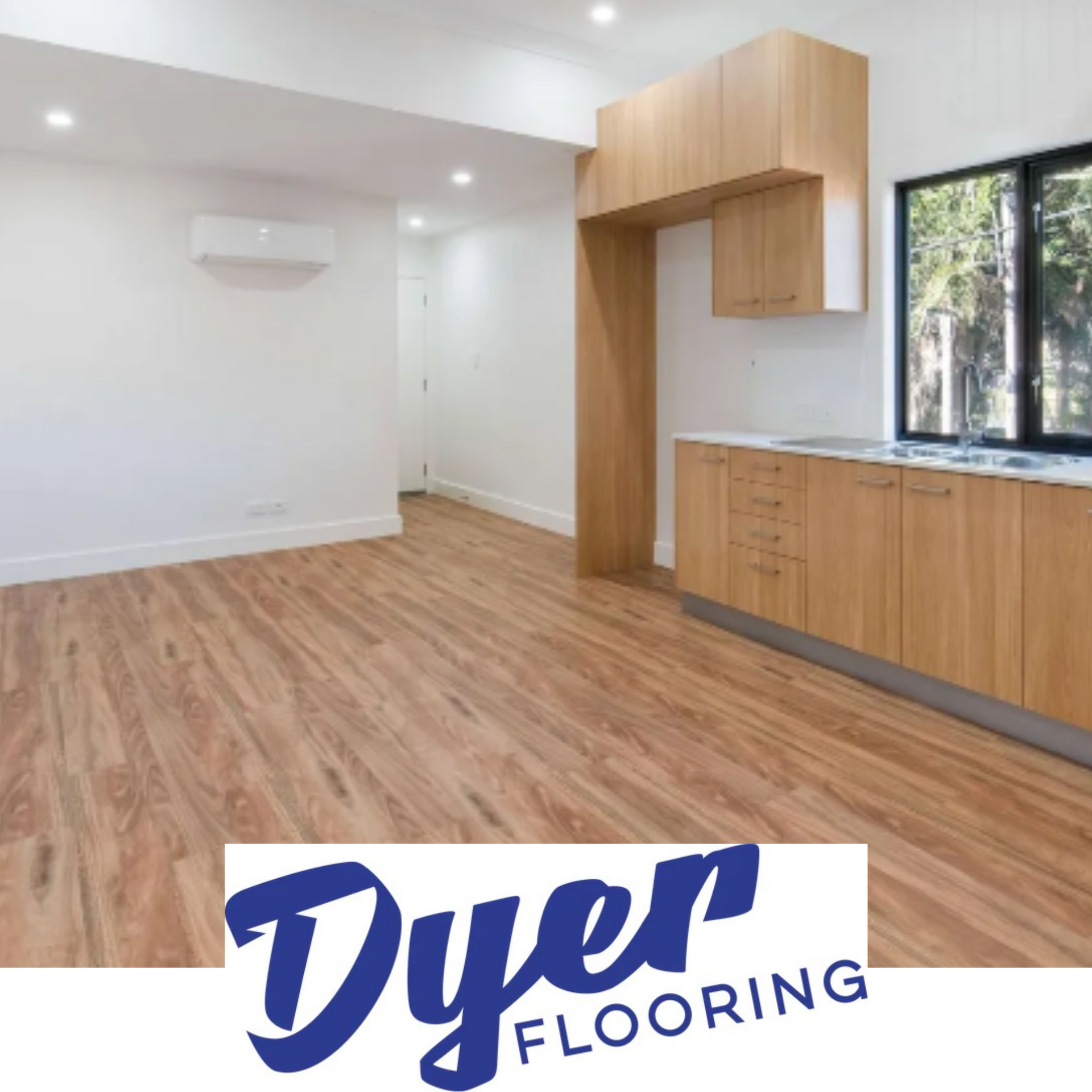 Light wood flooring in a kitchen with matching cabinetry and white walls. Dyer Flooring logo.