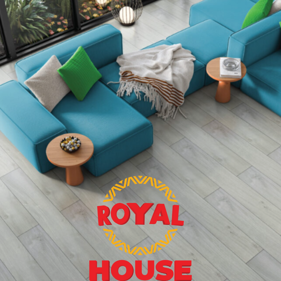 Blue sectional sofa with pillows, side tables, throw blanket, on light wood floor. 