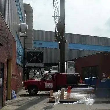 A Red Truck with a Crane on Top of it is Parked in Front of a Building | Wooster, OH | Bogner Construction Company