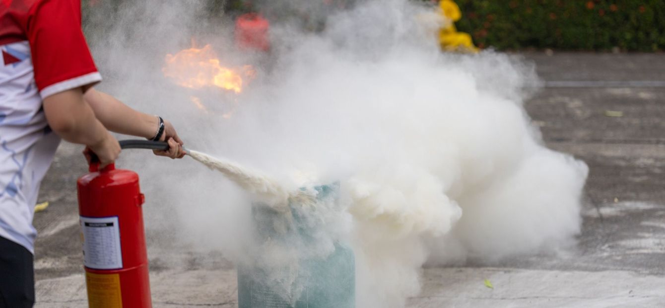 A person is using a fire extinguisher to put out a fire.