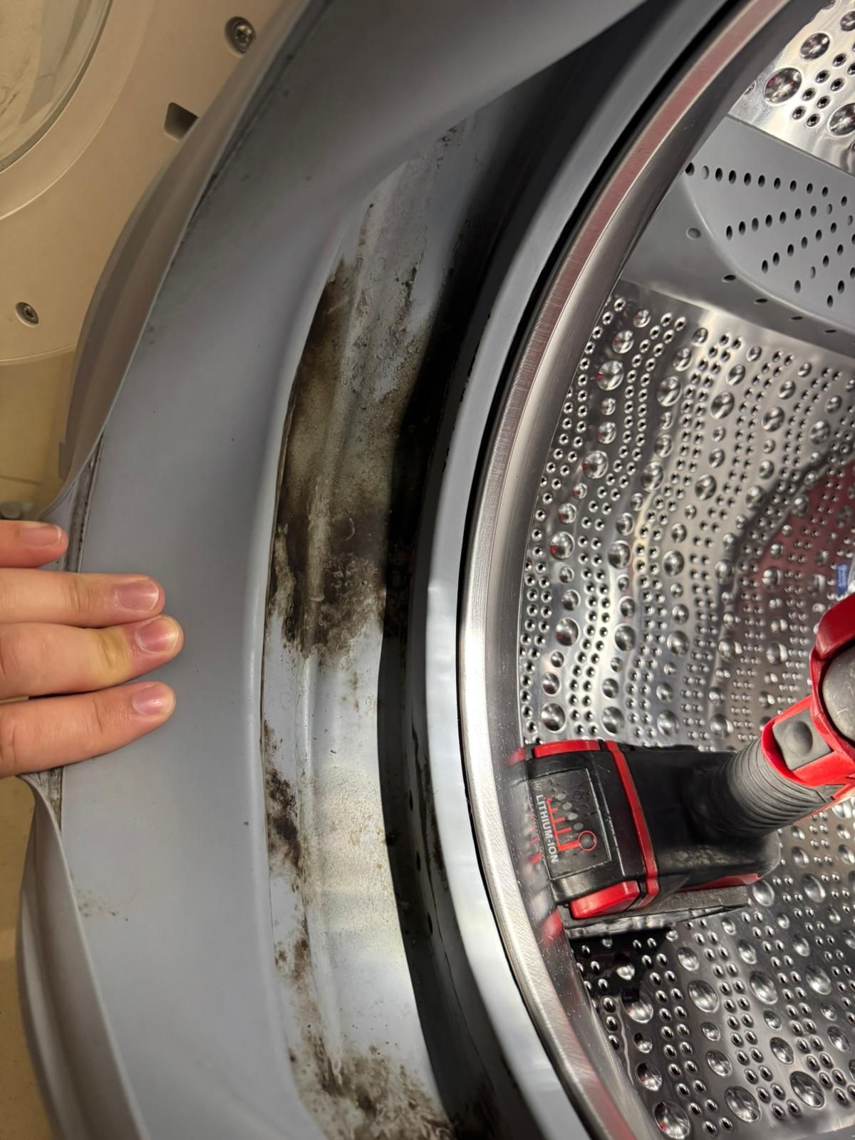 Technician from 5 Star Appliance Repair inspecting a dryer drum