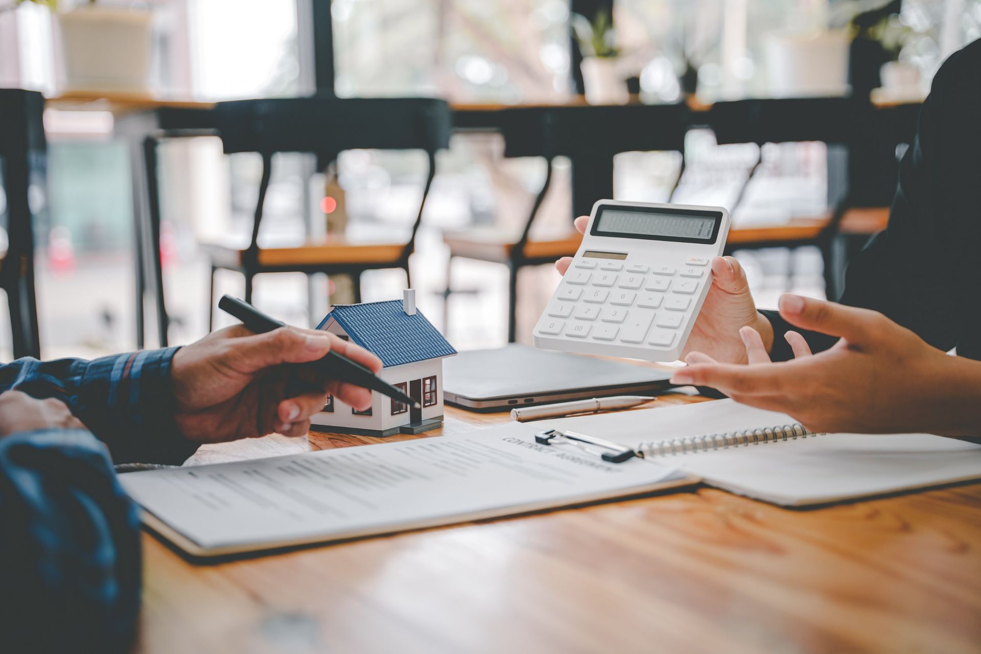 A man and a woman are sitting at a table signing a document.
