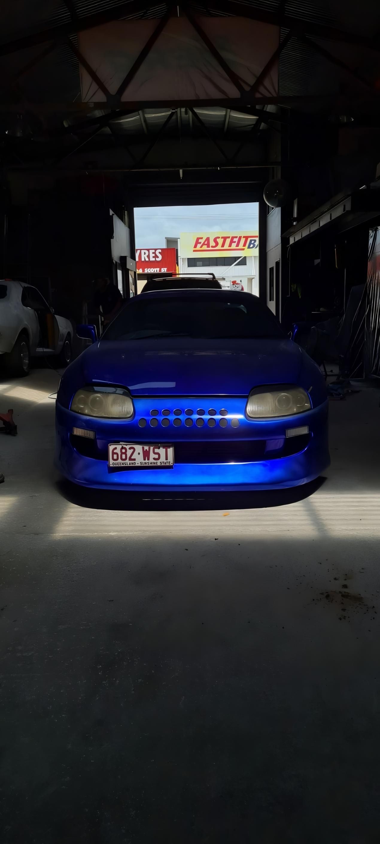 A Blue Car is Parked in a Garage — Dentmaster Refinishing In Bungalow, QLD