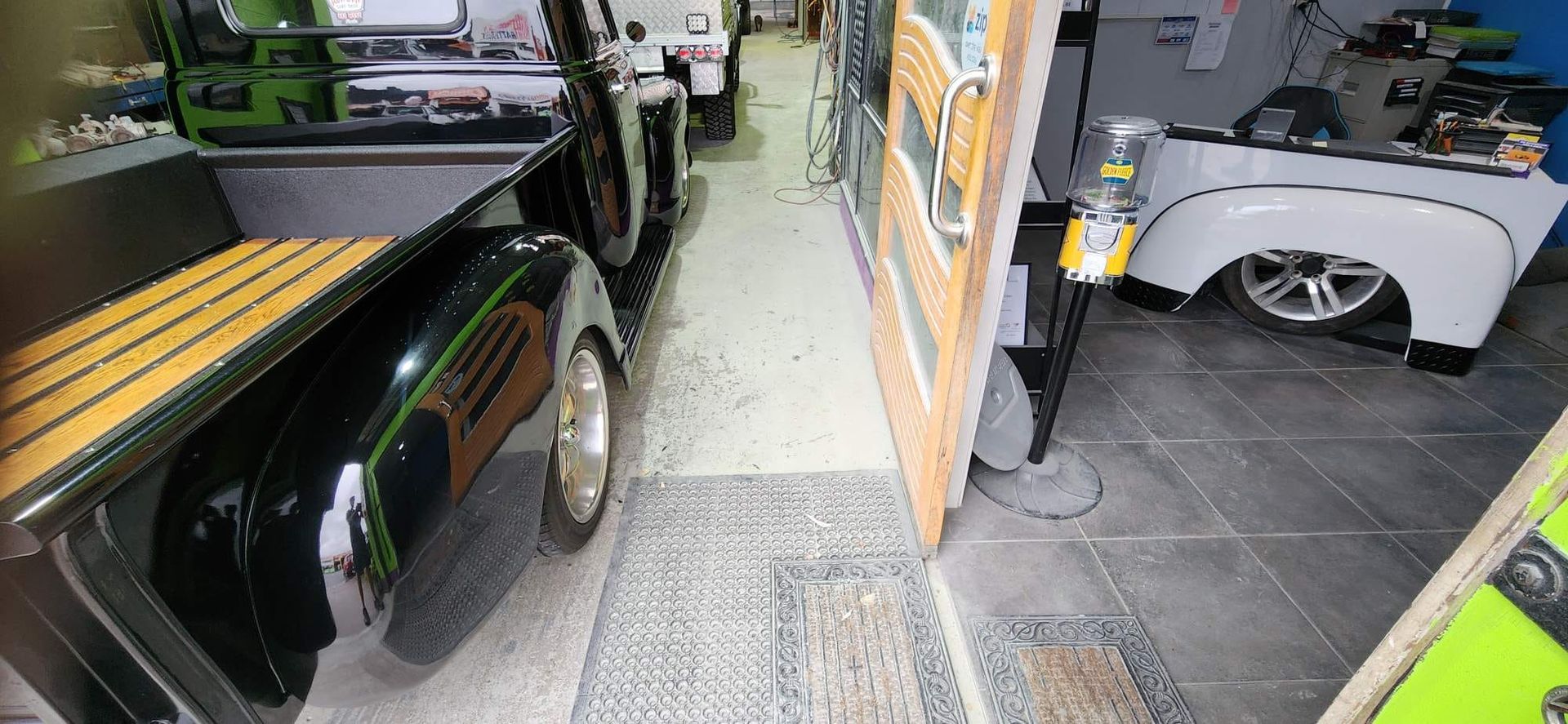 Black truck with wood bed and chrome details, parked inside a garage. -  — Dentmaster Refinishing In Bungalow, QLD