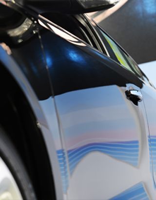 A Close Up of a Car With a Blue Stripe on the Side — Dentmaster Refinishing In Bungalow, QLD