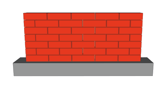 A red brick wall is sitting on top of a concrete base.