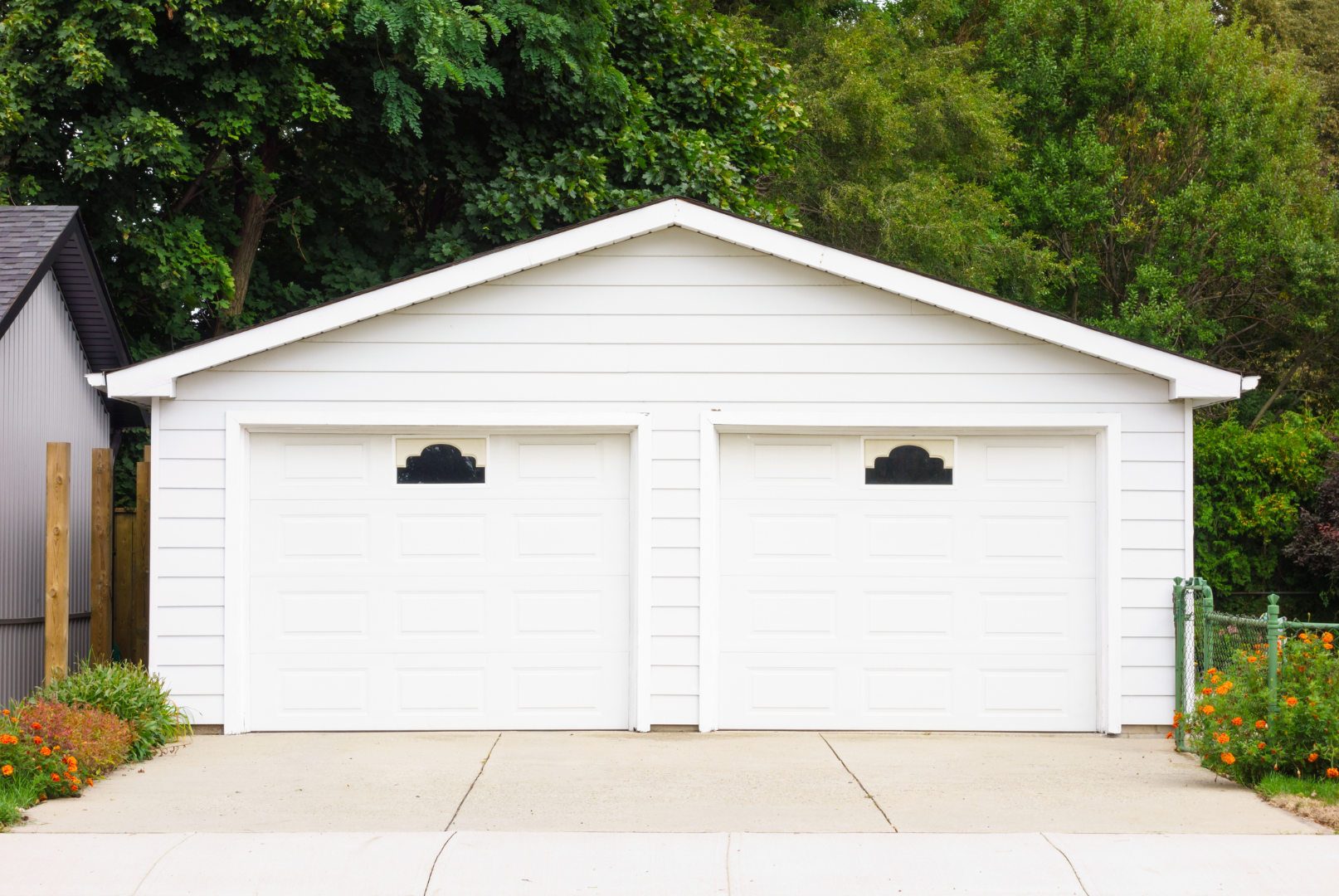 A modern, dark gray garage door with multiple rectangular glass panels. The door is closed and set in a matching gray frame.