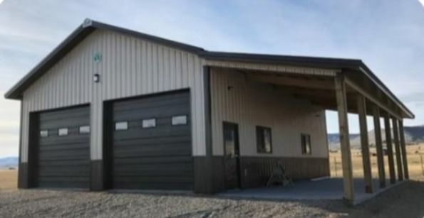 Two-bay garage with attached carport; light siding, dark garage doors, and a brown roof.
