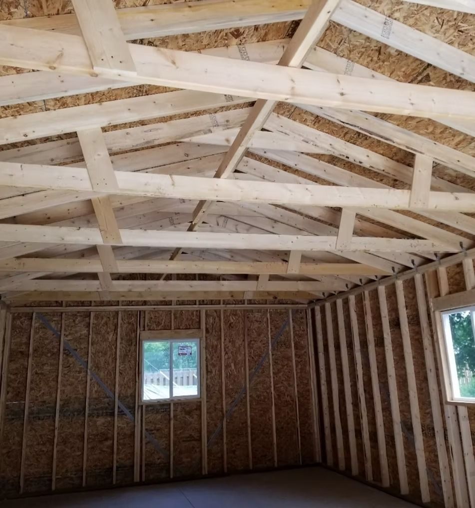 Interior view of a building under construction. Wooden beams and studs, oriented strand board walls and ceiling.