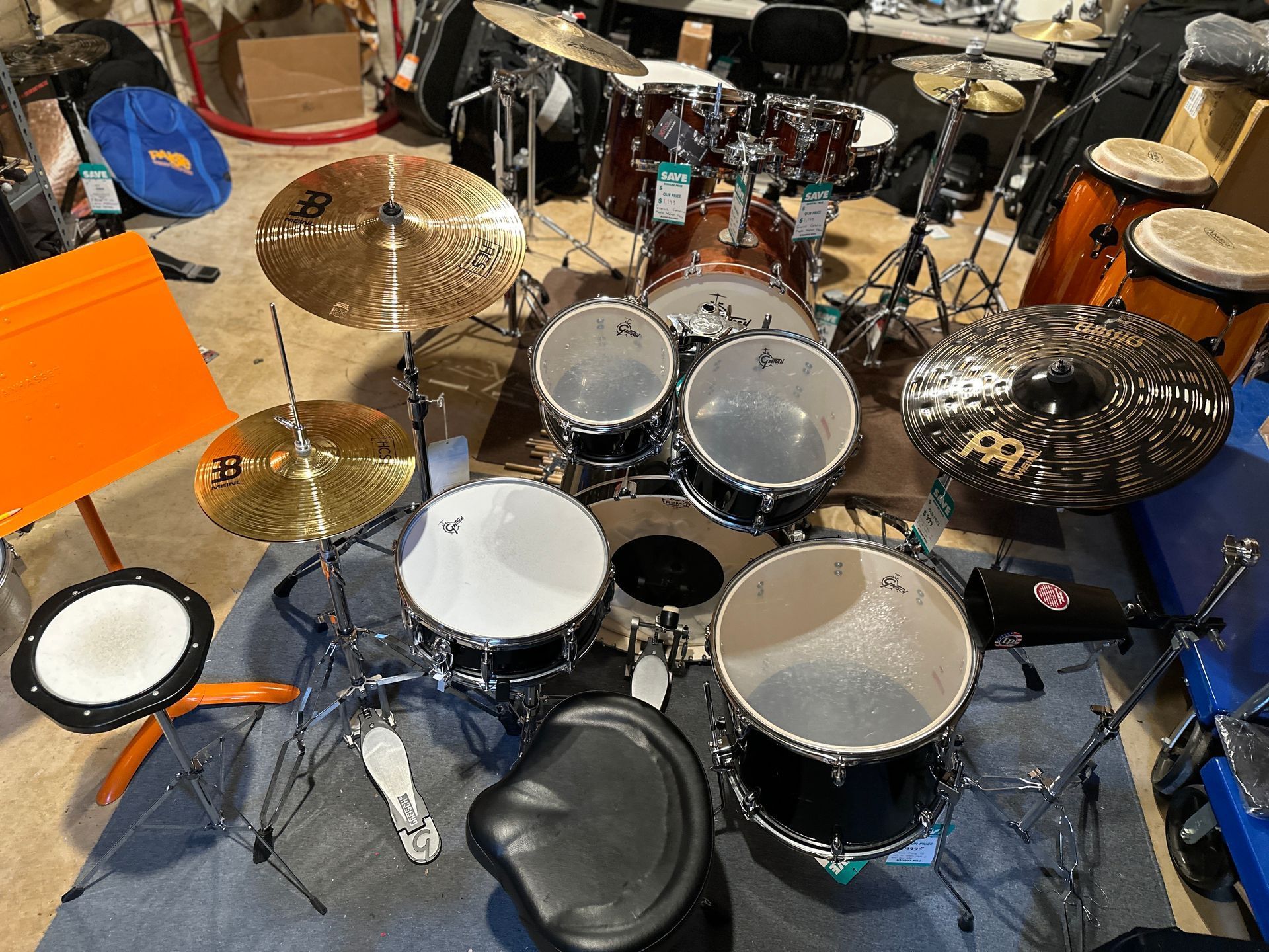 Drum kit with cymbals and electronic drum pad in a room.