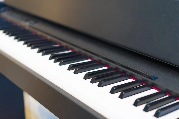 Close-up of piano keys, black and white, with red felt visible beneath keys.