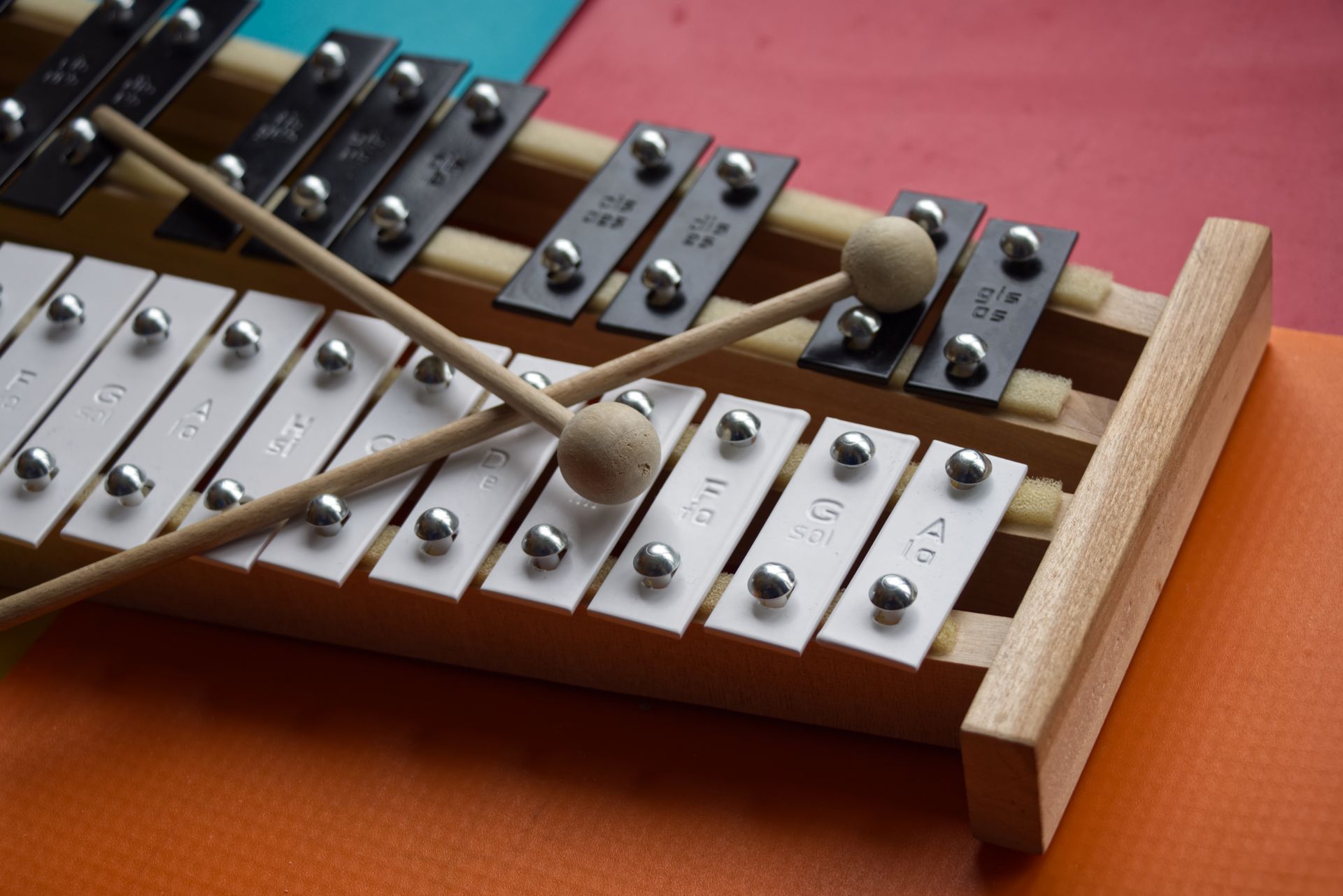 A glockenspiel with crossed mallets on a colorful surface.
