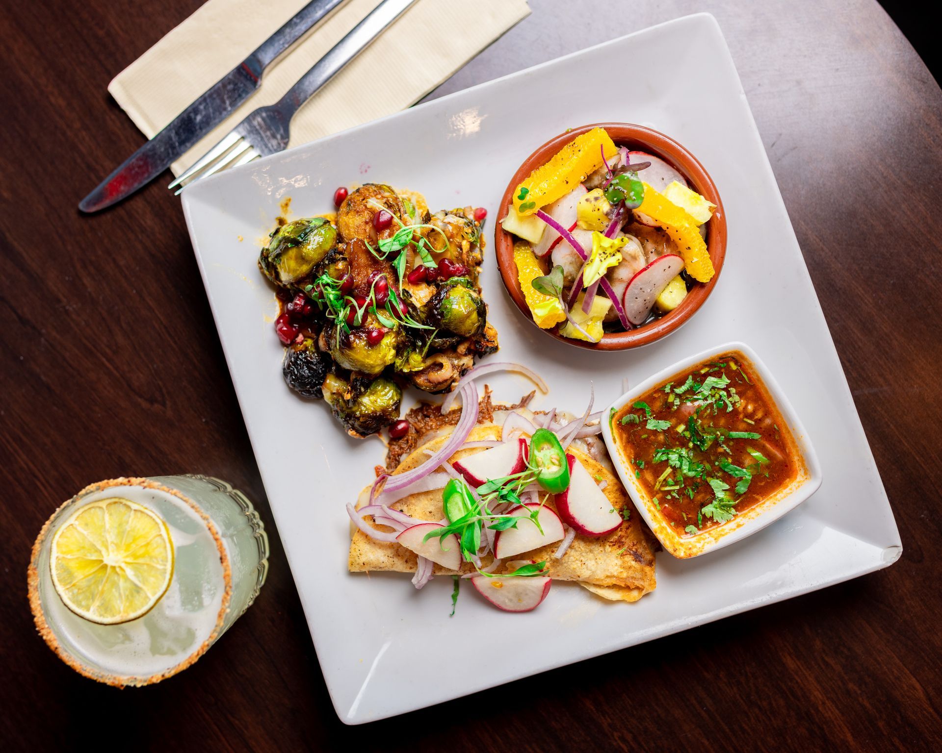 A plate of food on a table with a drink and a fork