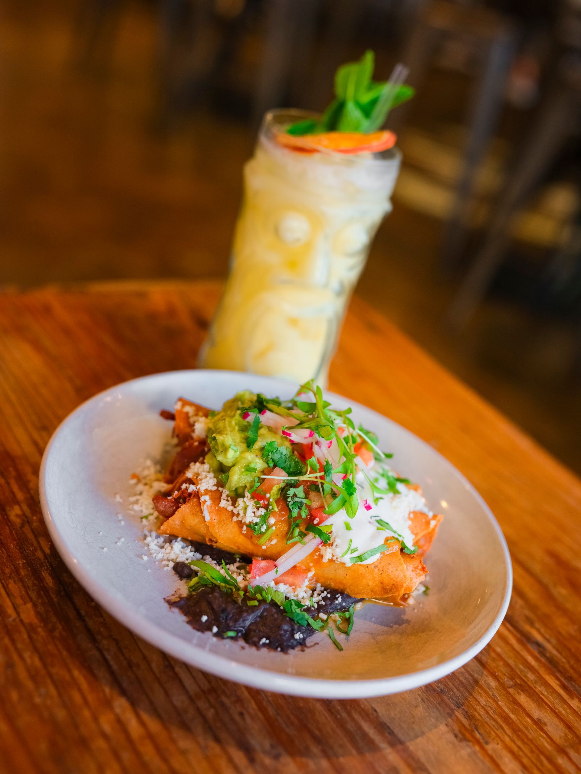 A plate of food and a drink on a wooden table.