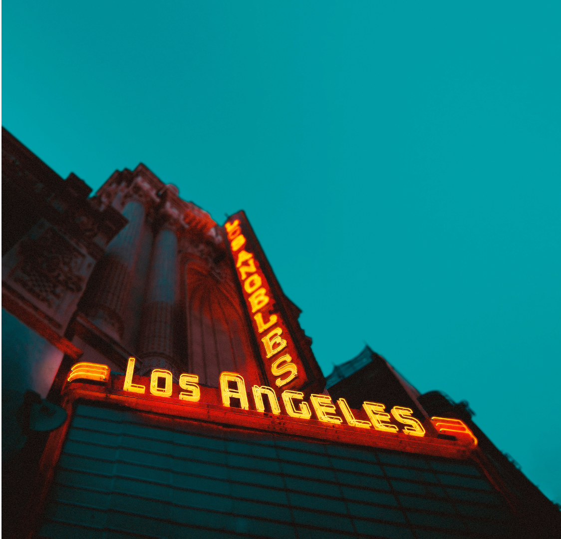 A car is being towed down the street by a tow truck.