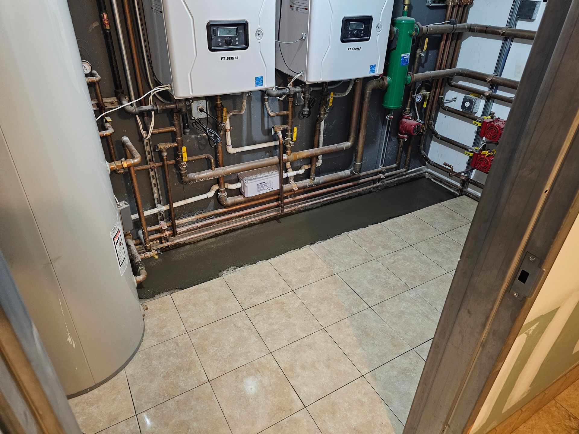 A room with a lot of pipes and a water heater