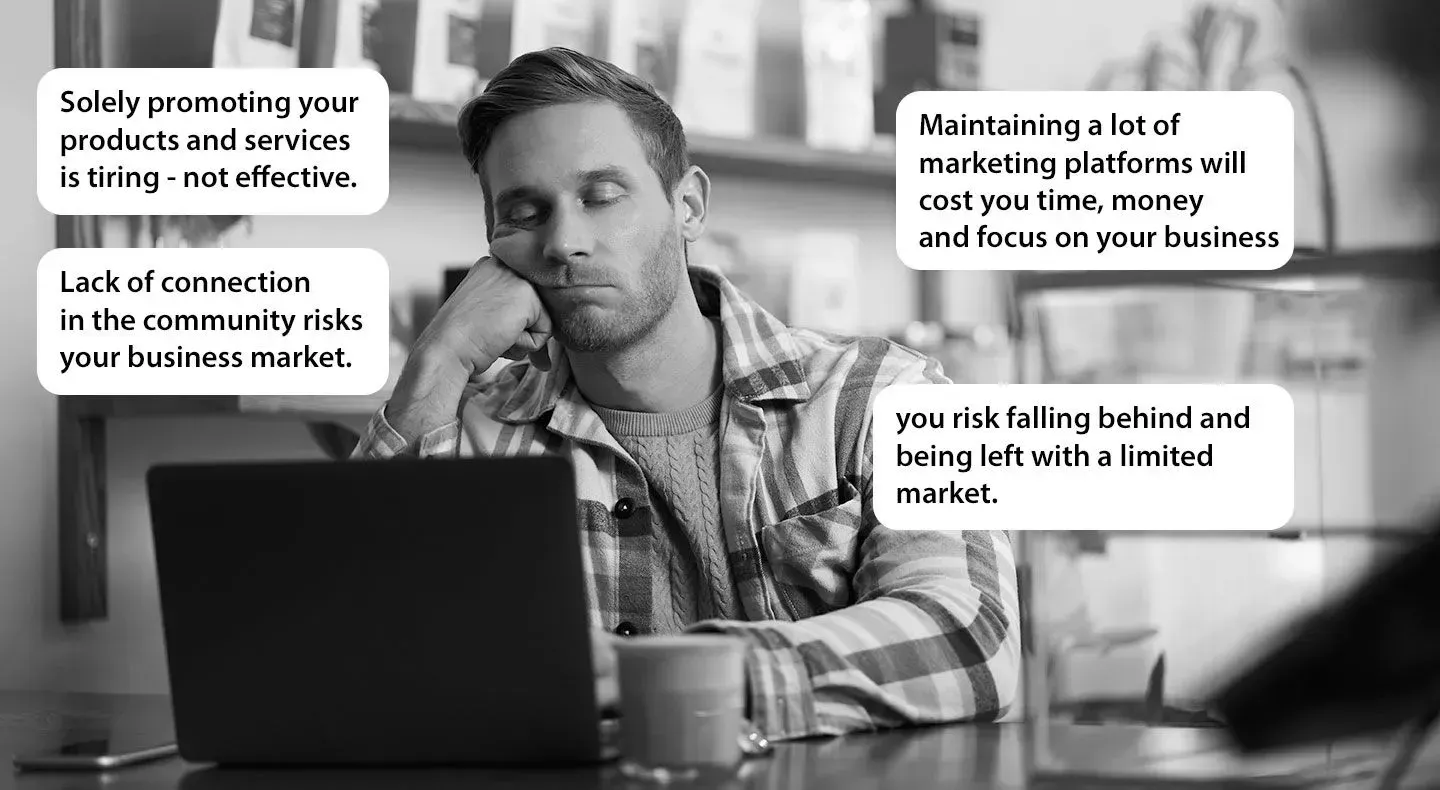 A man at a laptop with thought bubbles expressing marketing challenges, looking tired and thoughtful.