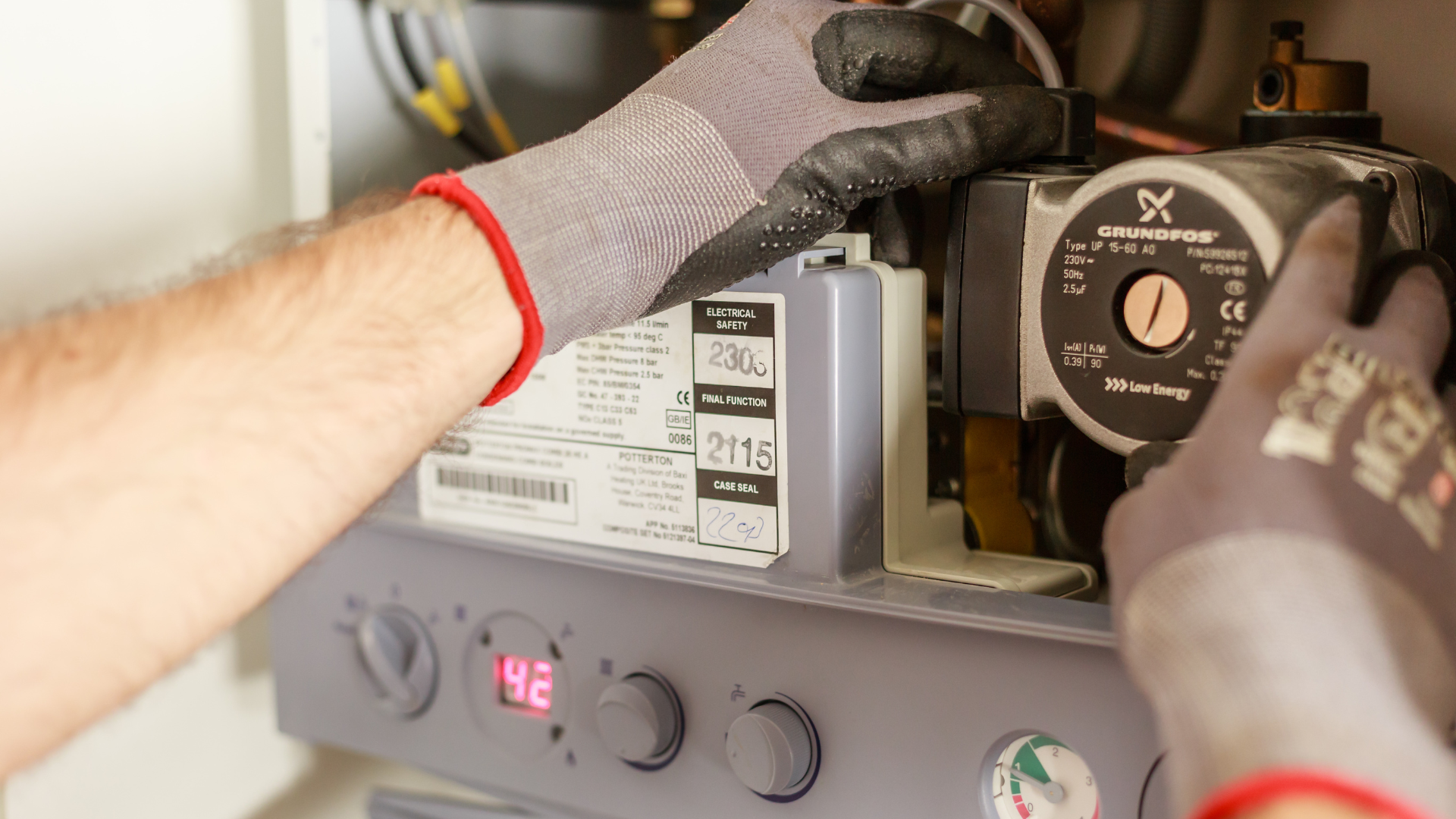 A man wearing safety glasses is working on a heater.