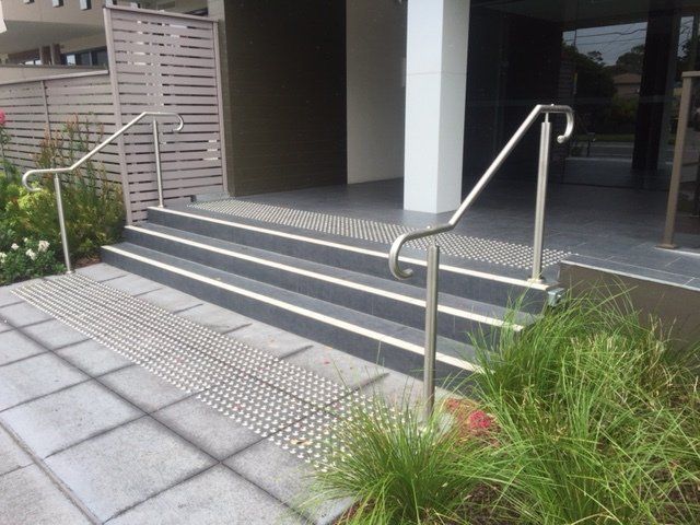 A small set of 3 steps with stainless steel handrails on either side