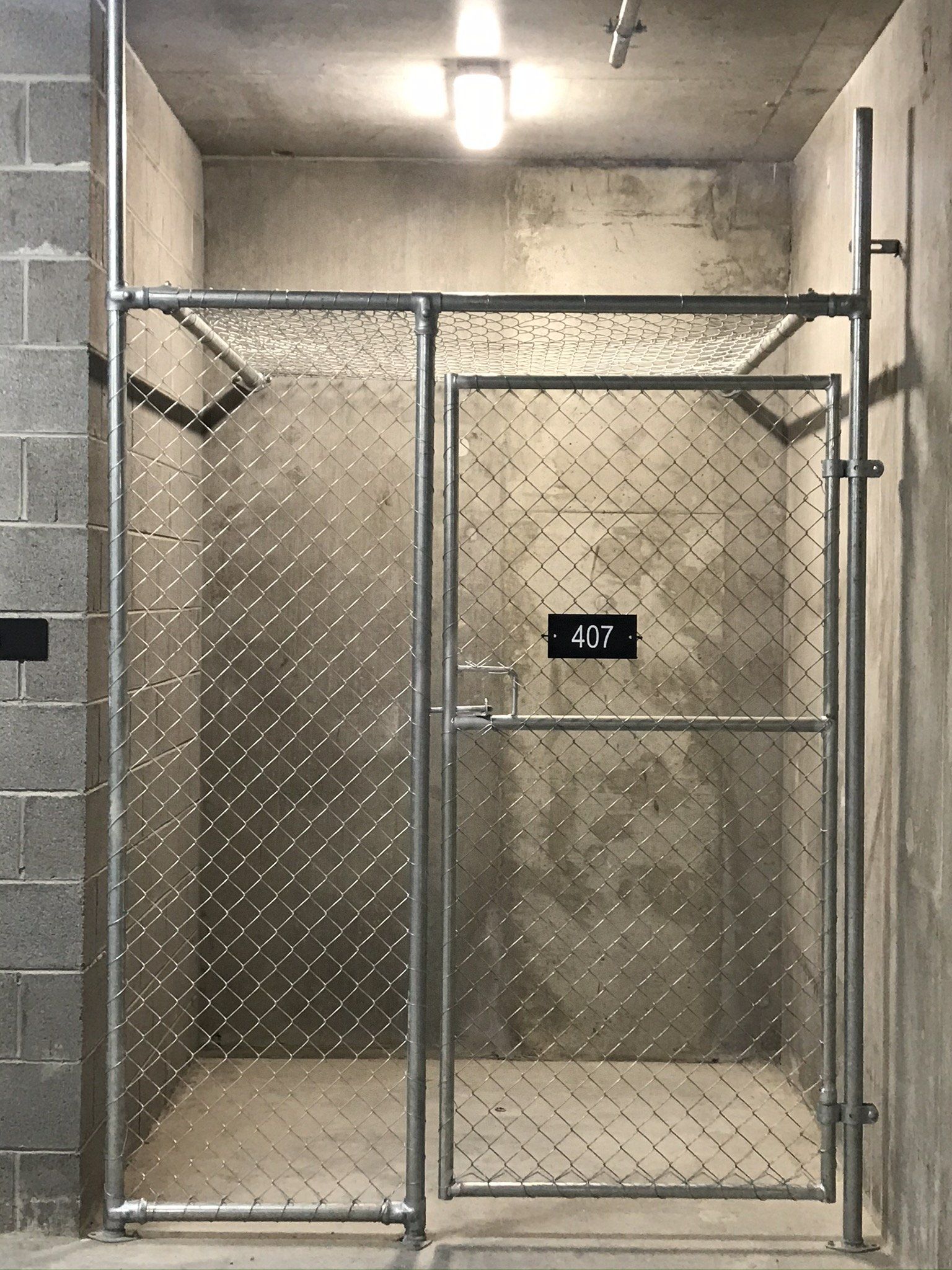 Chain mesh storage cage in an alcove with a roof