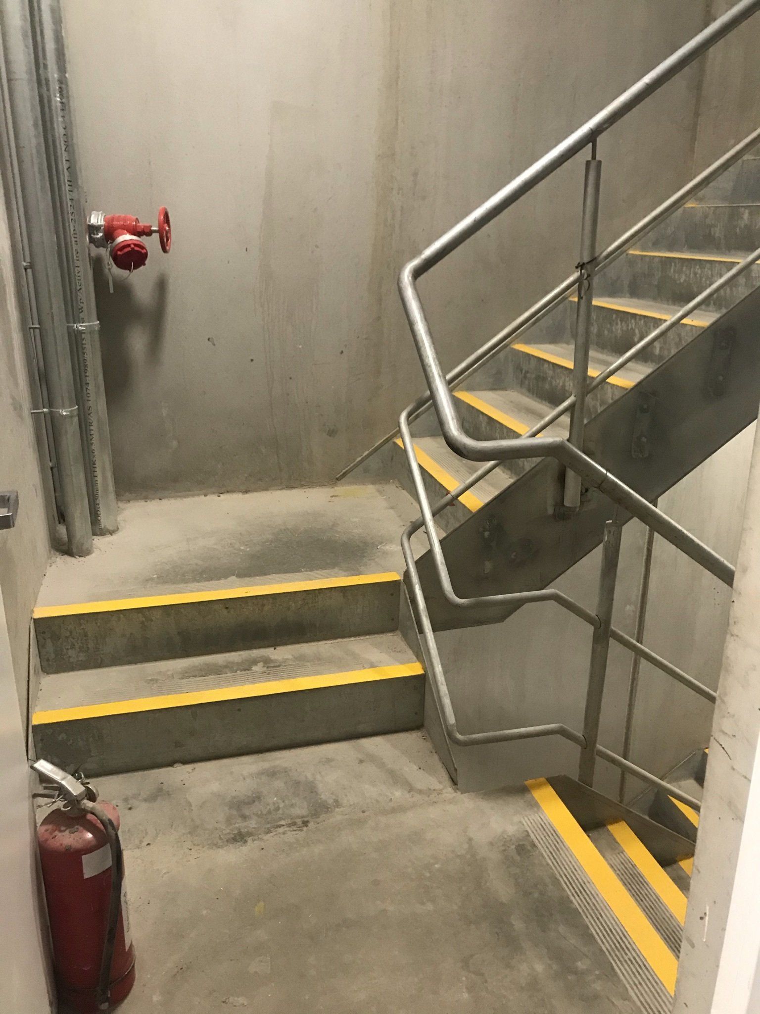 Galvanised steel fire stair handrails with yellow anti slip stair nosing