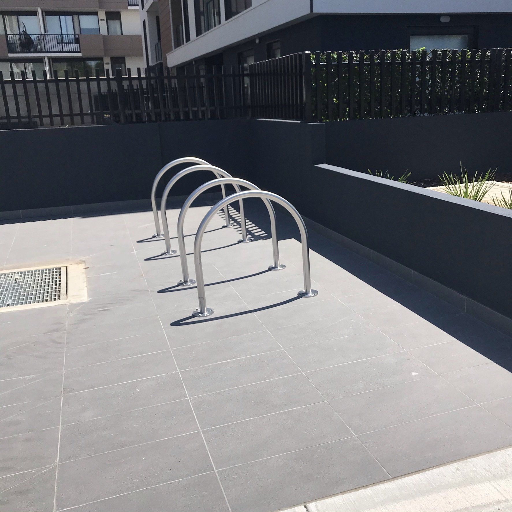 Stainless steel bike hoop storage racks bolted to a concrete floor