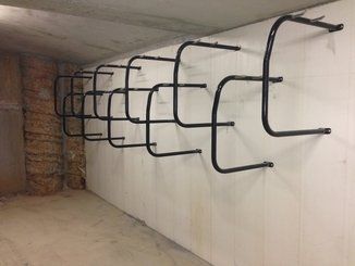 Row of hanging type bike racks on a wall