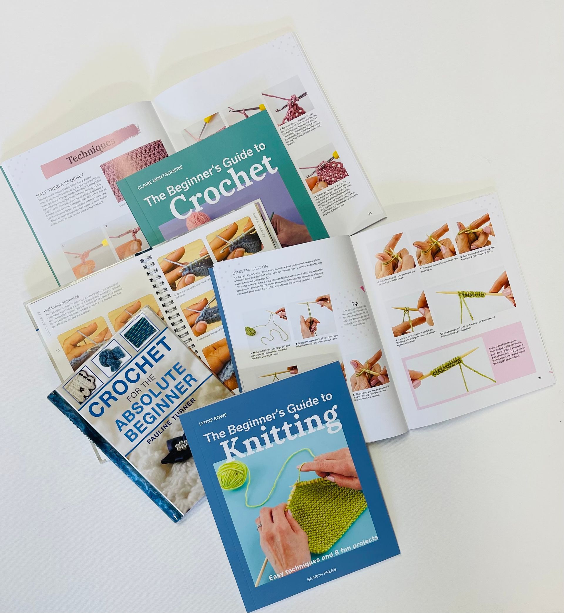 A bunch of books on crochet and knitting are laying on a table