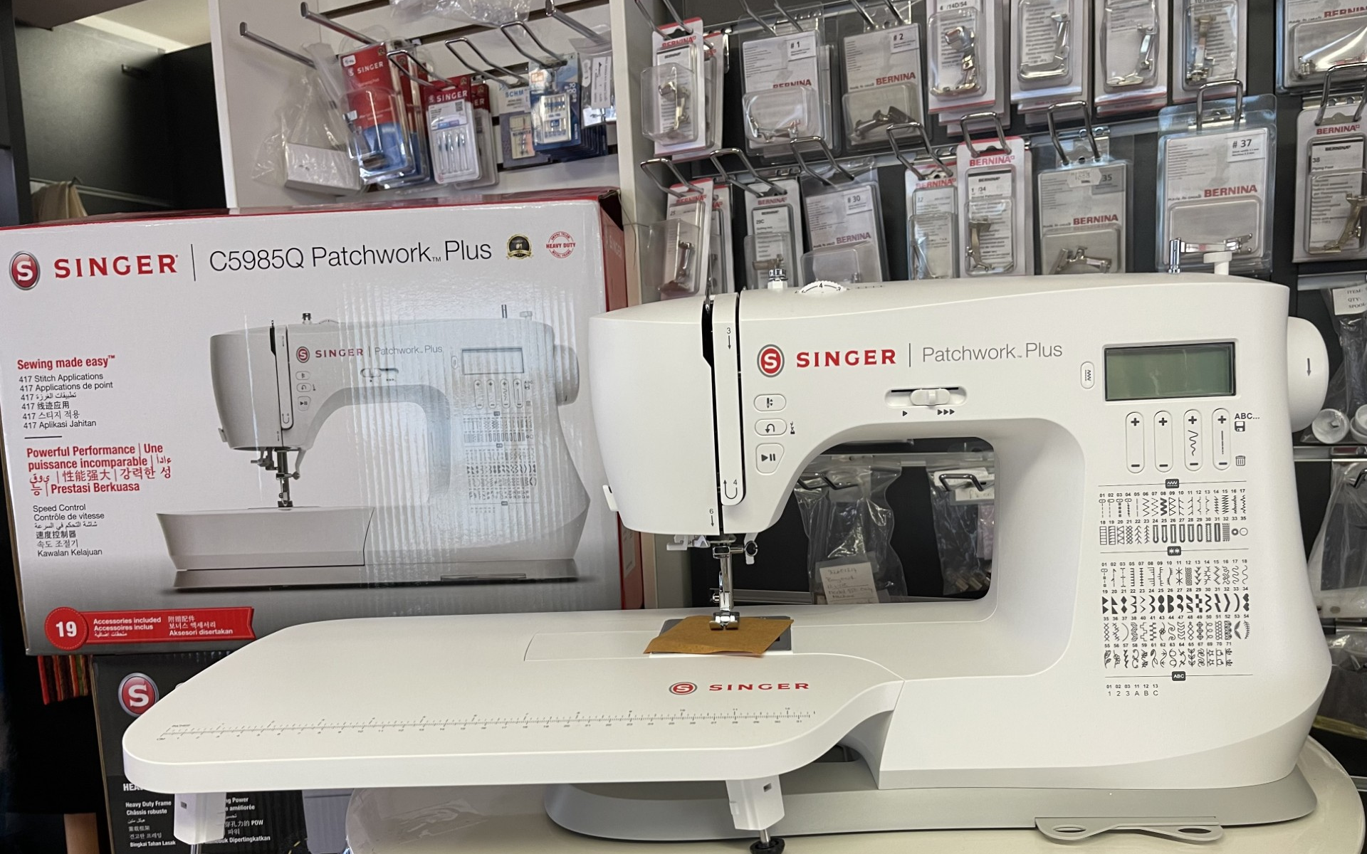 A singer C5985Q Patchwork Plus sewing machine is sitting on a table in a store