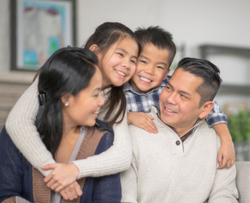 A family is posing for a picture while sitting on a couch.