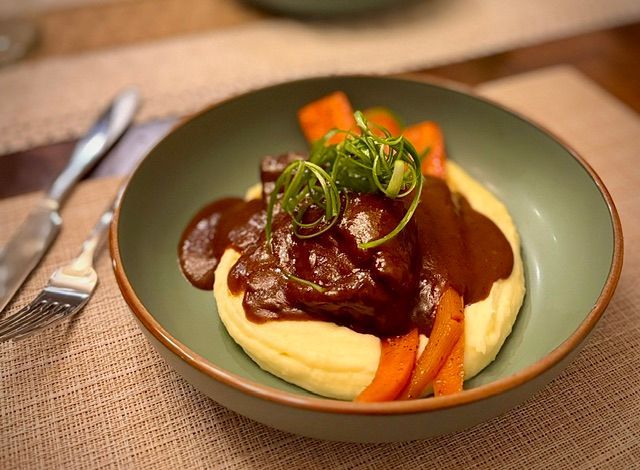 Braised beef over whipped garlic potatoes and slow roasted carrots