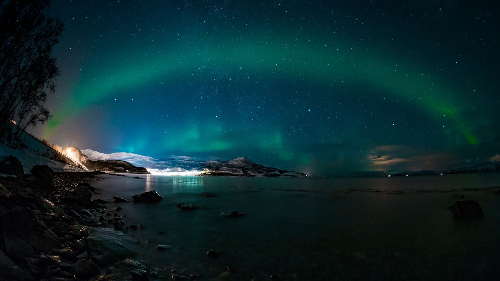 The aurora borealis is shining over a body of water.