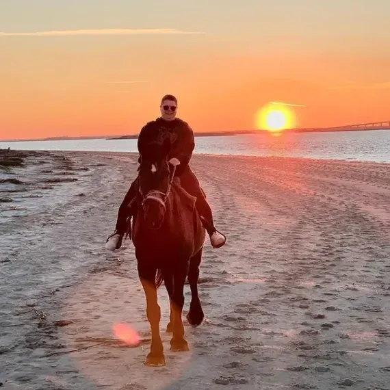 A person is holding a pineapple in a bag in a grocery store.