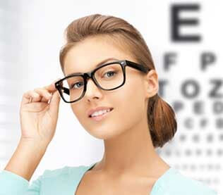 Young woman face in eyeglasses with eye chart — Eye & Contact Lens Clinic in Bremerton, WA