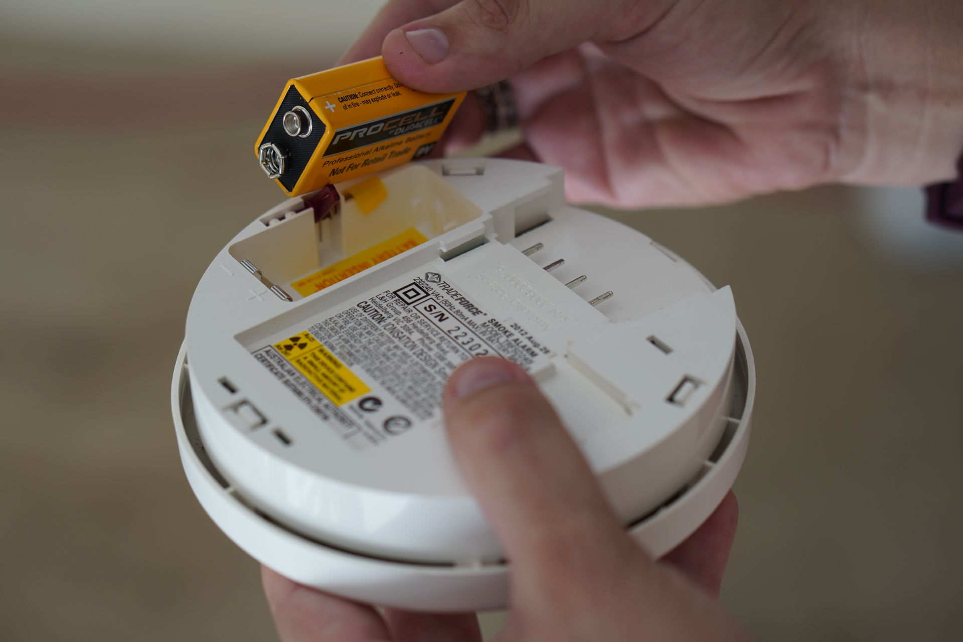 Local Smoke Alarmed expert fitting a new smoke alarm in a coastal Queensland home