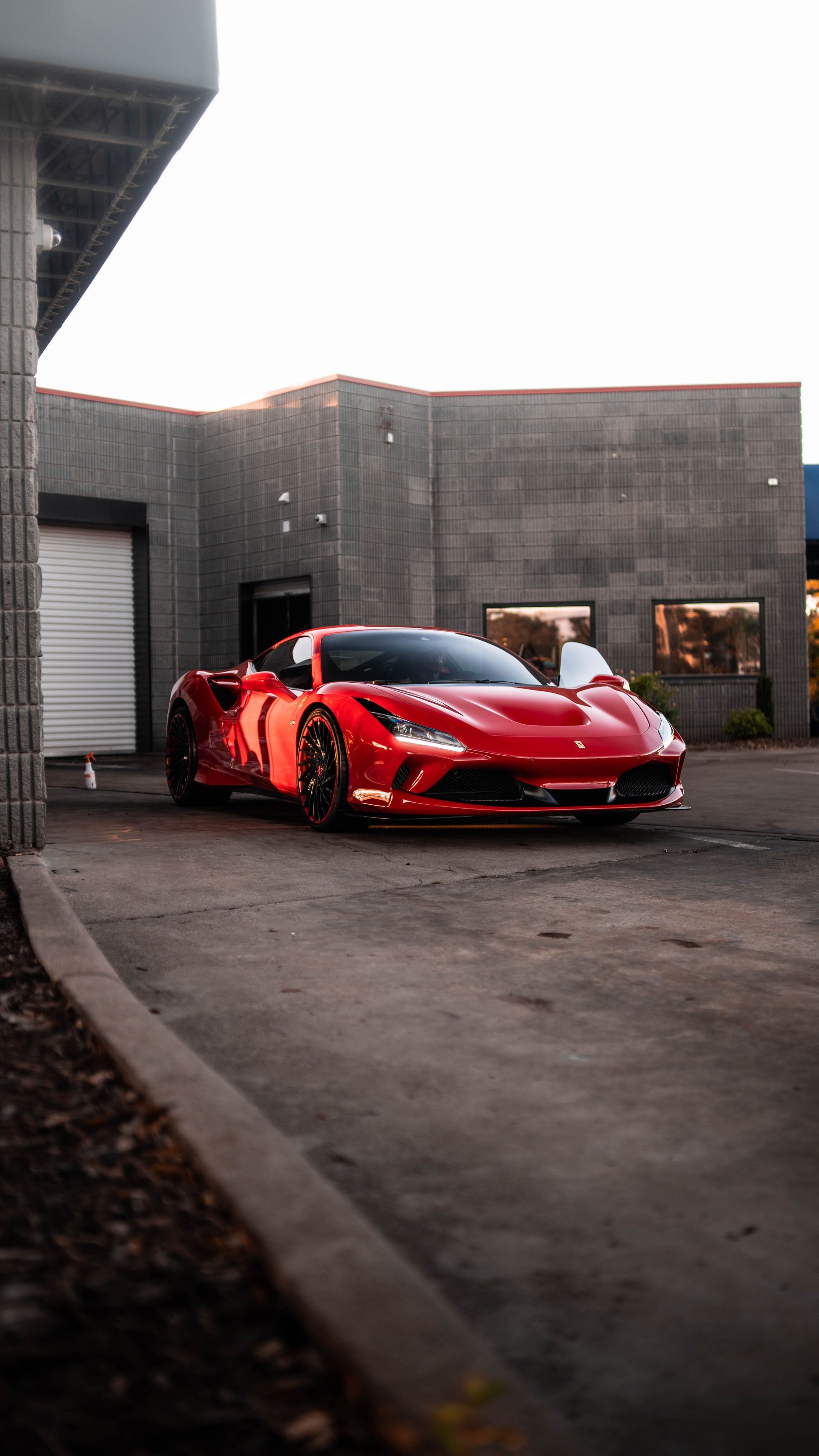 A red sports car is parked in front of a building.