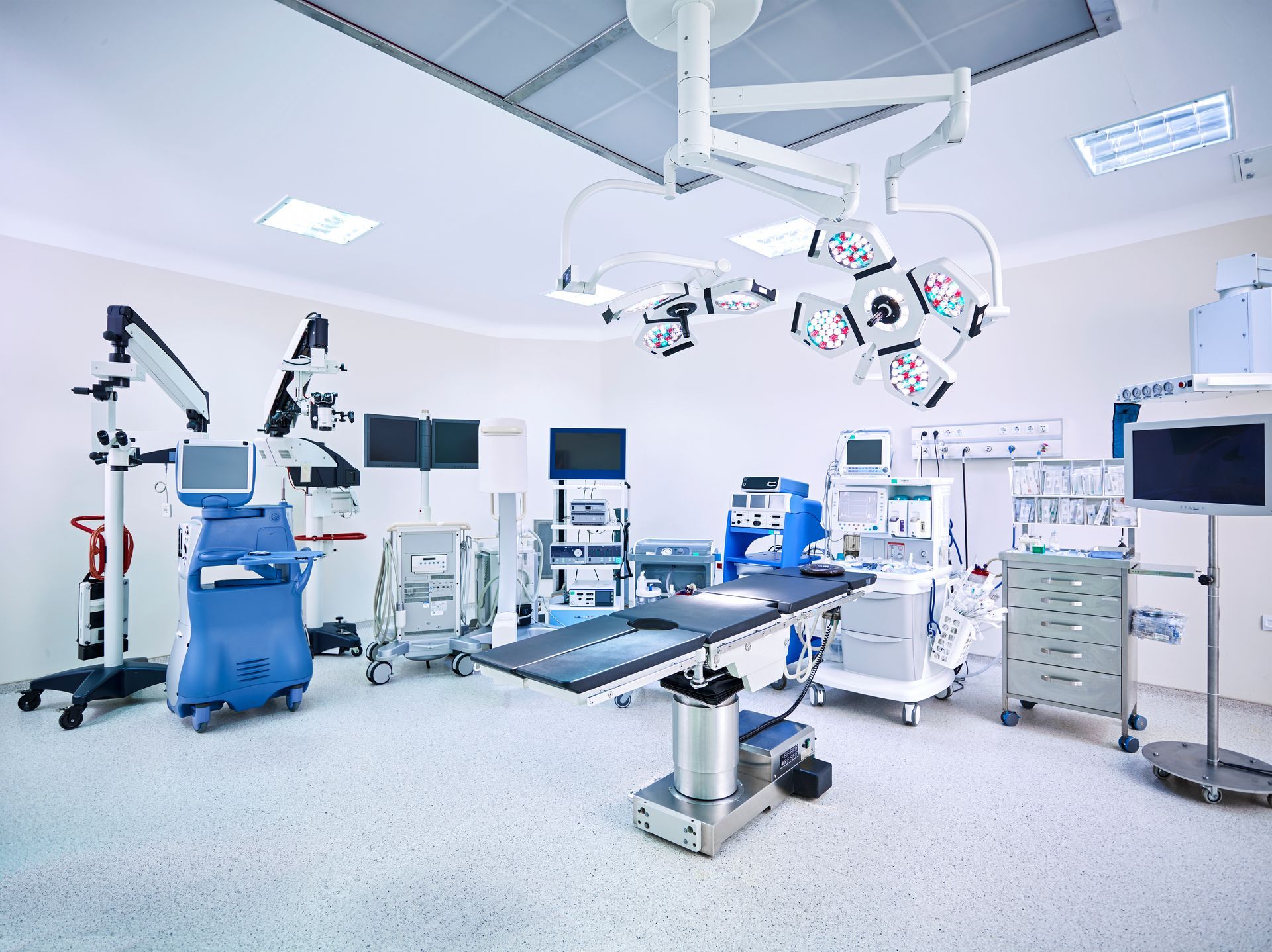 Operating room with surgical table, medical equipment, and bright lights.