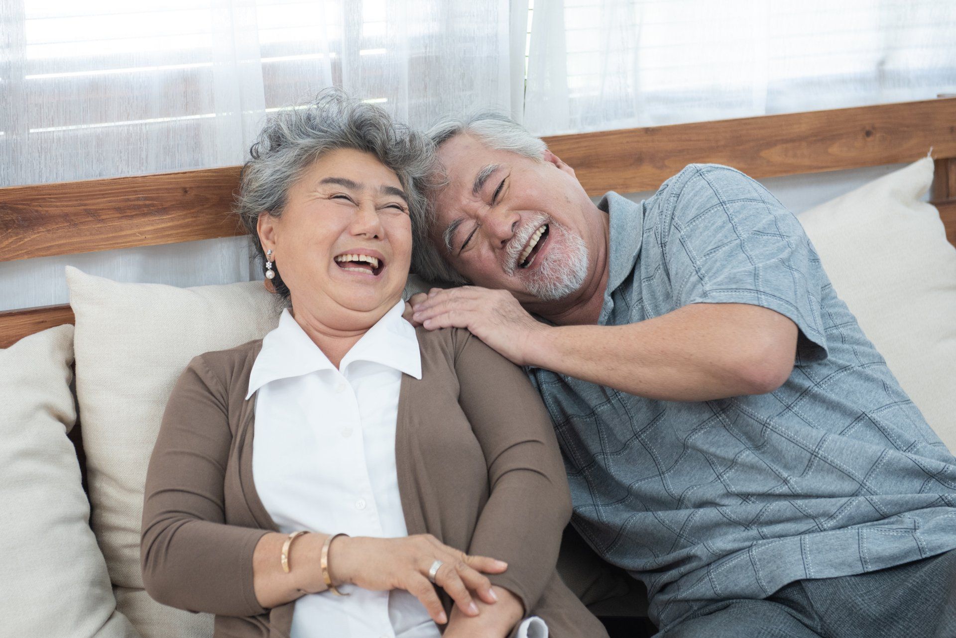 Older couple laughing with new bonded teeth