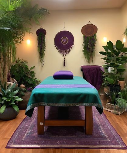 A massage table with a purple pillow on it in a room surrounded by plants.
