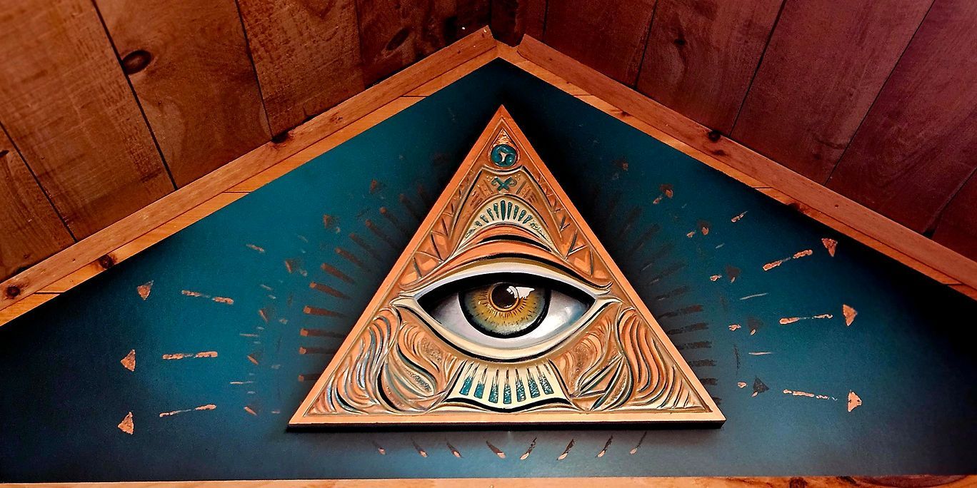 An all seeing eye in a triangle on a wooden wall.